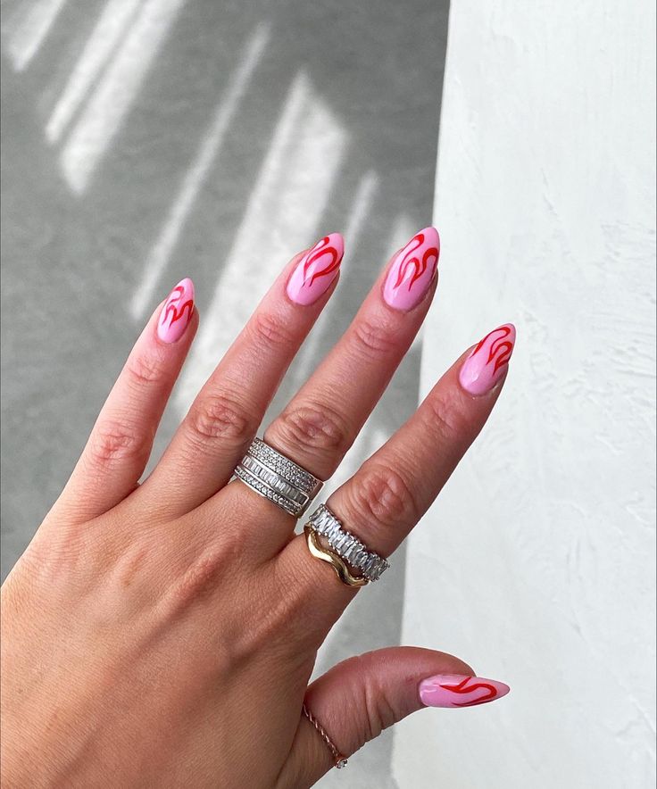 Whimsical Pink and Red Almond Nail Design with Drip Effect and Chic Ring Accents.