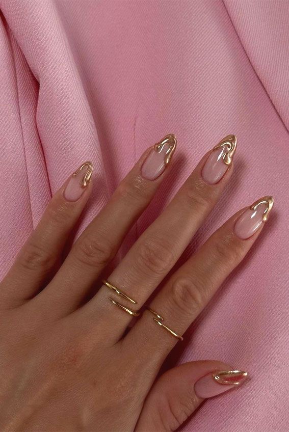 Chic Nail Design: Delicate Pink Polish with Unique Gold Accents and Minimalistic Rings