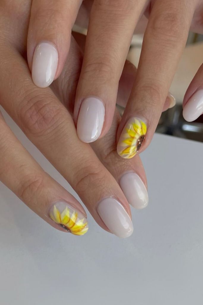 Charming Nail Design: Neutral Base with Cheerful Sunflower Accents for Nature-Inspired Elegance.