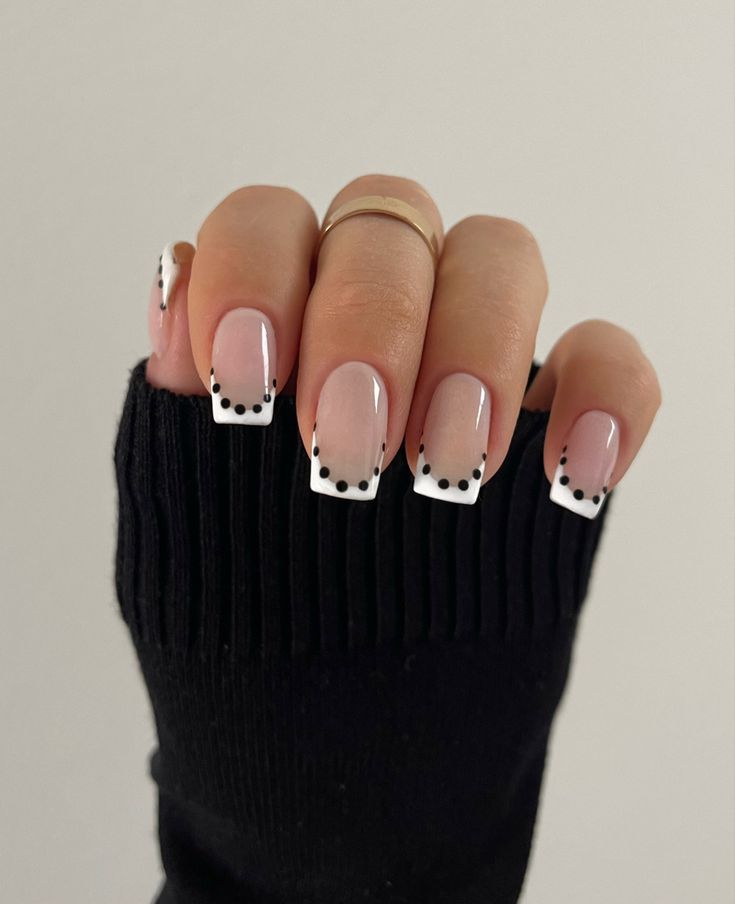 Elegant French Tip Nail Design with Playful Black Dot Accents