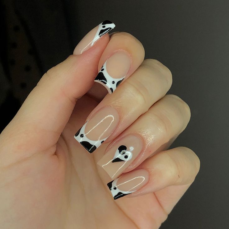 Chic Cow Print Nail Art: Bold Black and White Patterns with Glossy Finish.