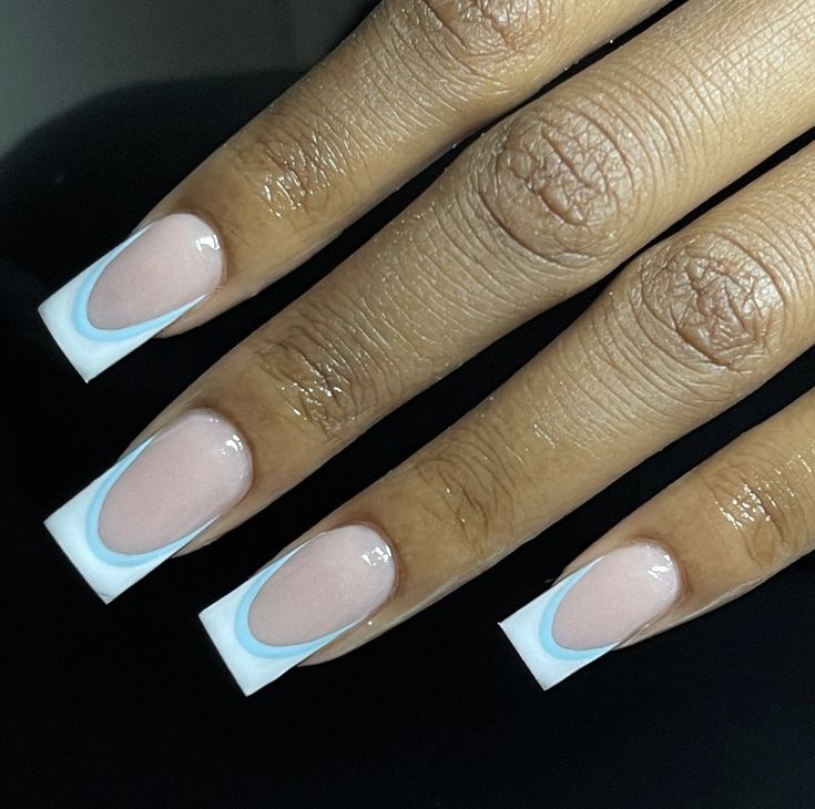 Chic Oval Nail Design: Soft Pink with Bold White Tips and Subtle Blue Accents.