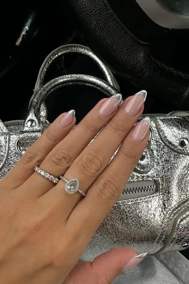 Sophisticated Nail Design: Soft Nude Base with Classic White Tips and Glamorous Accents.