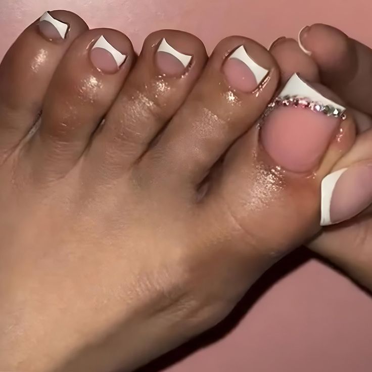 Chic and Glamorous Elegant Pedicure with White Tips, Soft Pink Base, and Rhinestone Accents.