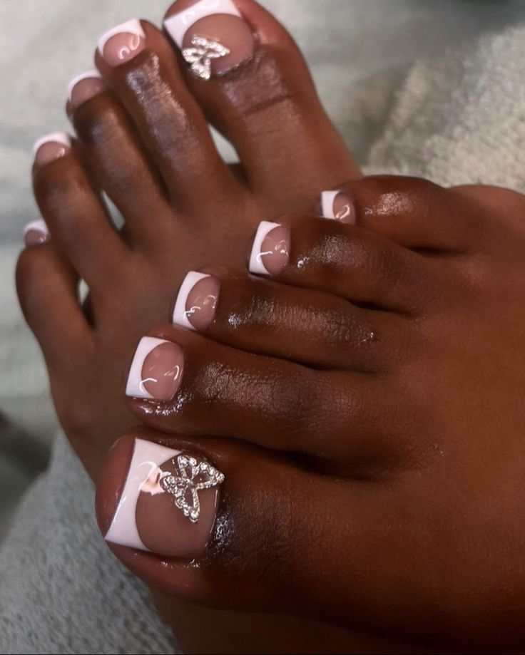 Sophisticated French Tip Pedicure with Modern Embellishments.