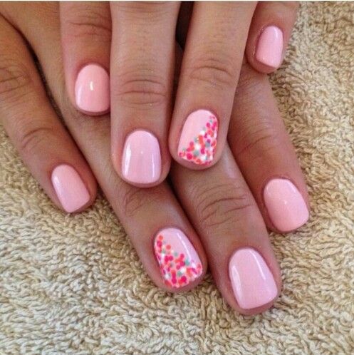 Whimsical Pastel Pink Nails with Colorful Accent Dots for a Soft, Feminine Look.