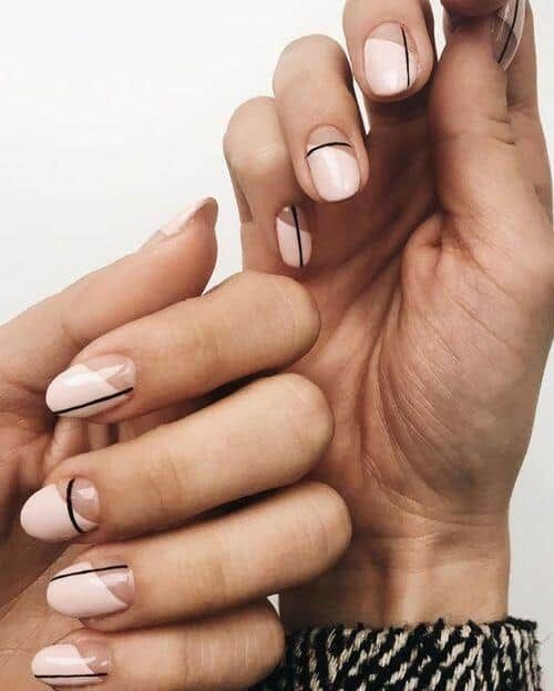 Elegant Modern Nail Design: Soft Pink Base with Sleek Black Lines and Geometric Shapes.