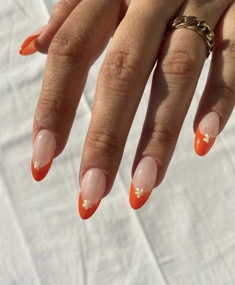 Bold Orange French Tip Nails with Feminine Floral Accents for a Playful Elegance.