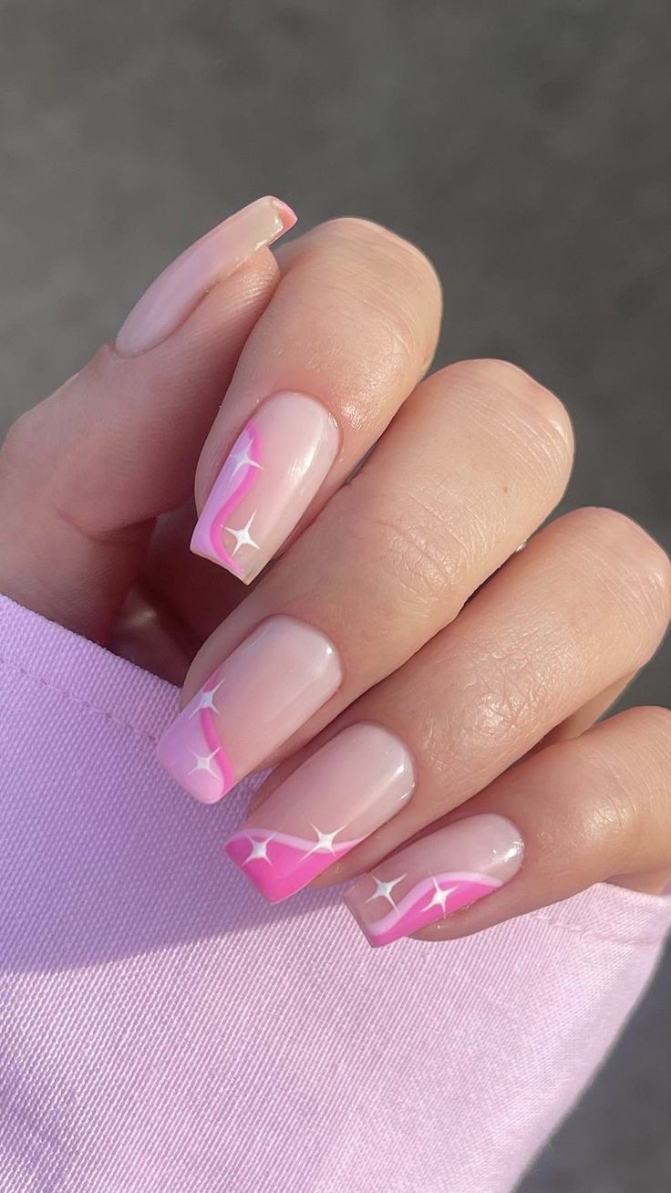 Delicate Soft Pink Ombre Nails with Shimmering Star Accents for a Playful Aesthetic.