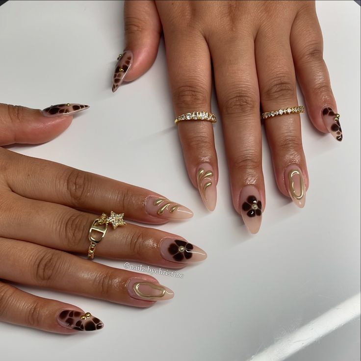 Chic Nude Nail Art with Artistic Brown Patterns, Floral Motifs, and Gold Accents.