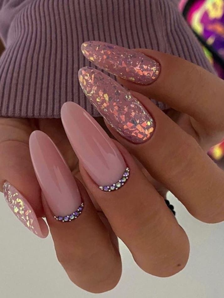 Chic Nail Art: Soft Pink Base with Shimmering Holographic Accents and Rhinestone Details.