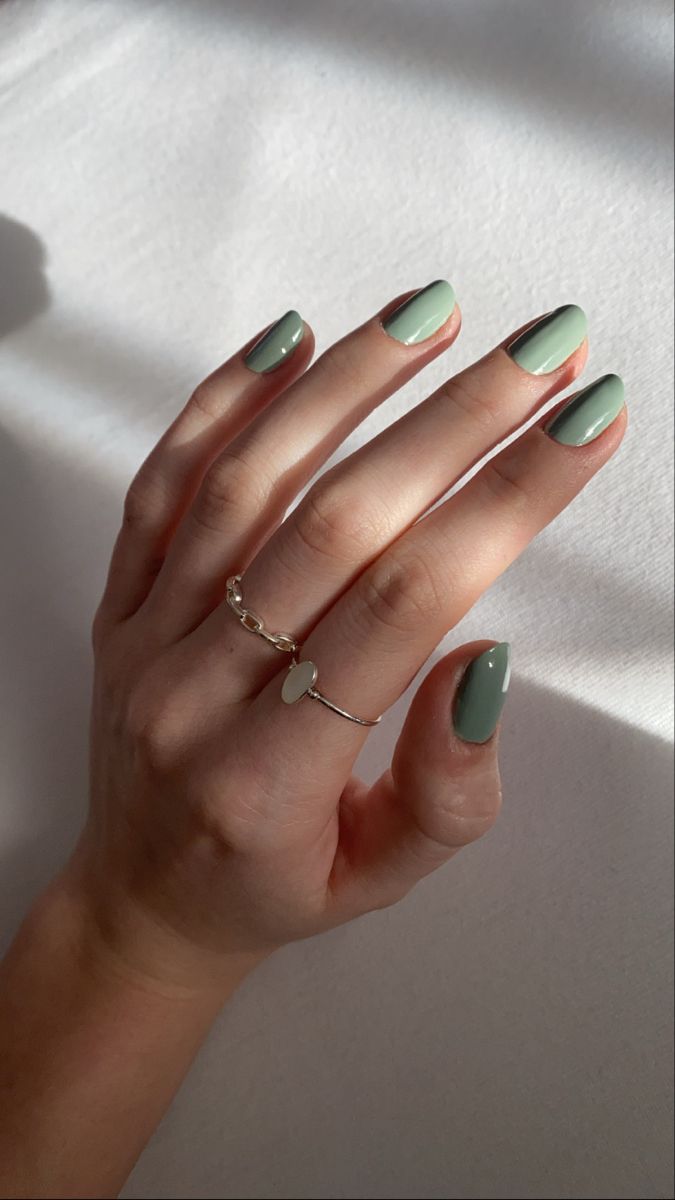 Chic Soft Green Almond Nail Design with Glossy Finish and Minimalist Silver Accents.