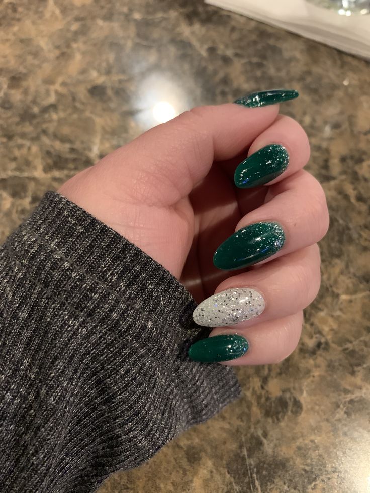 Elegant Oval Nail Design: Deep Green Base with Sparkly Silver Accents