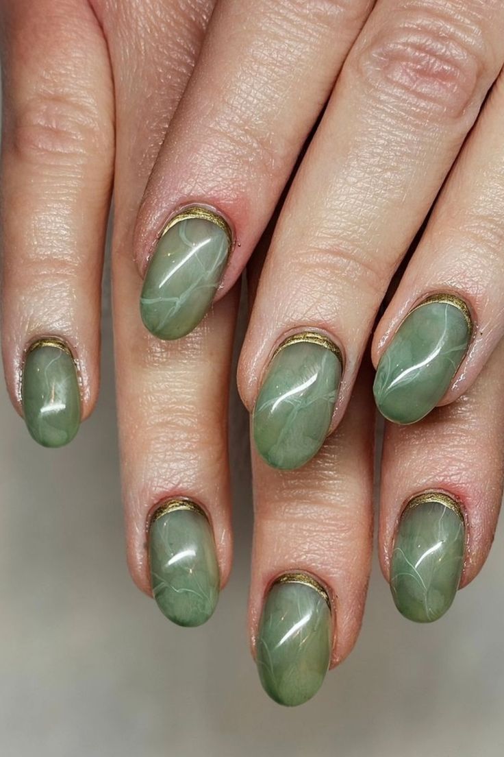 Elegant Green Marble Nails with Glossy Finish and Luxurious Gold Accents.