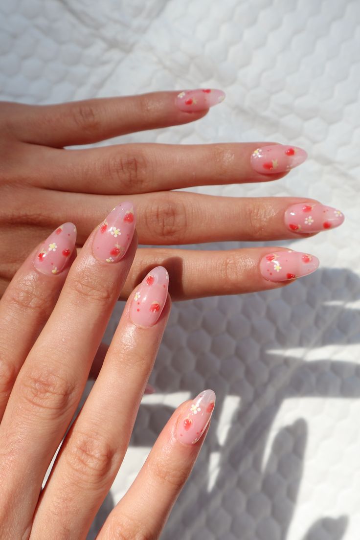 Delicate Pink Floral Nail Design with Whimsical Red and White Accents in Elegant Shape.