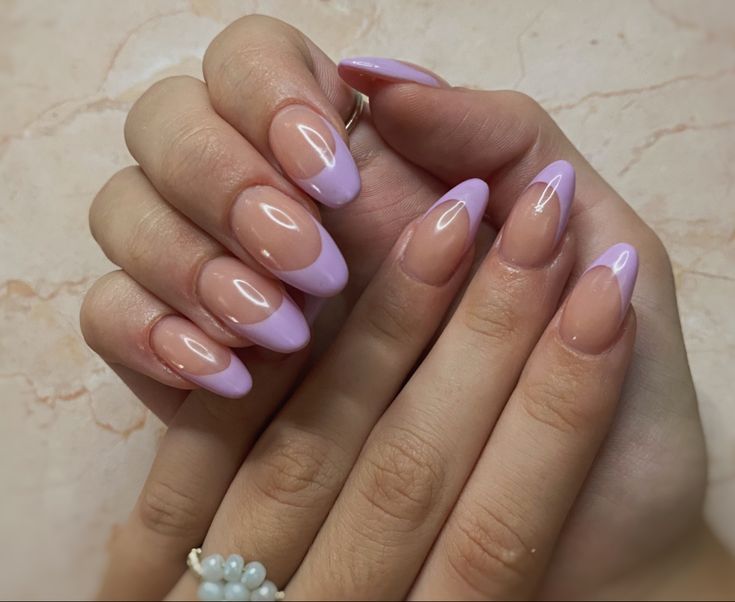 Sophisticated Almond-Shaped Nail Design: Nude and Soft Lavender French Tips with Glossy Finish.