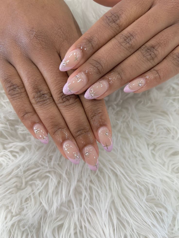 Sophisticated Nail Design: Natural Base with Pink Tips, Floral Accents, and Subtle Glitter.