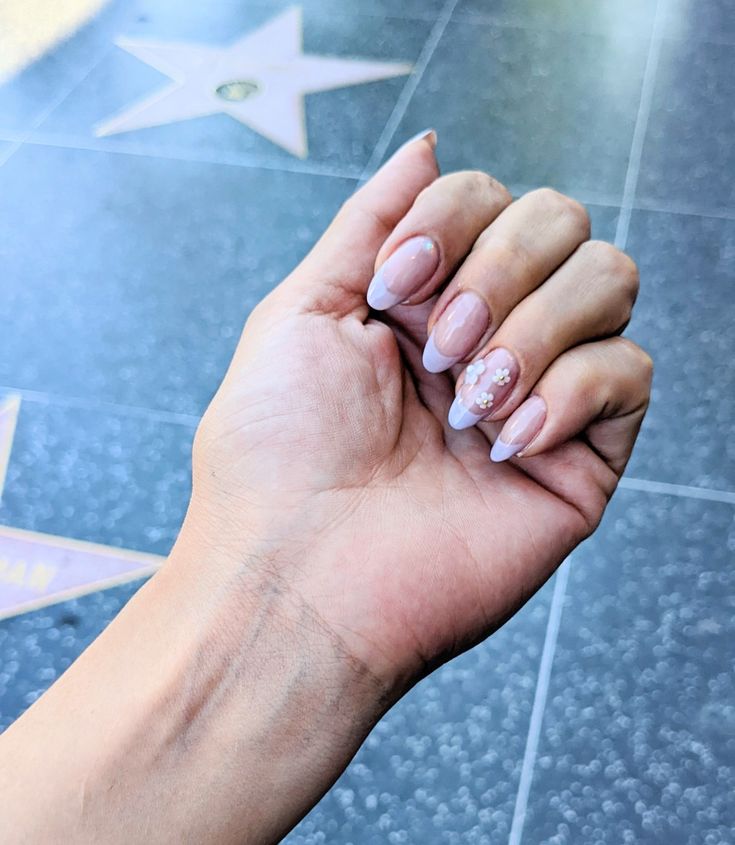 Chic Soft Pink Nail Design with White Tips and Floral Accents