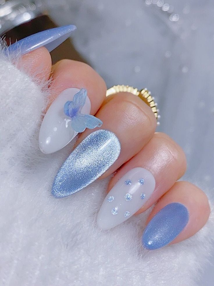 Chic Delicate Blue Nail Design with Textured Finishes and Whimsical Butterfly Accents.