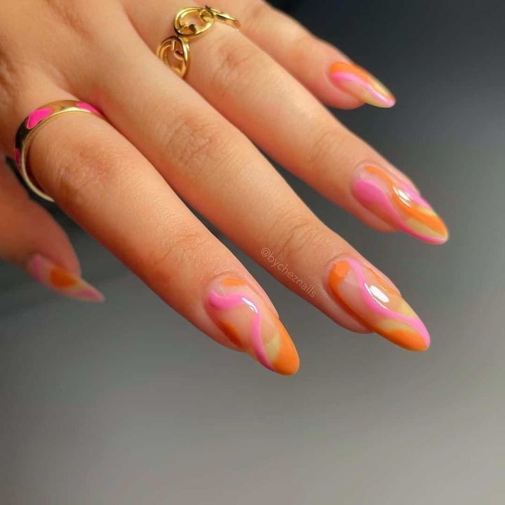 Chic Almond-Shaped Nail Design with Orange, Pink, and Peach Swirls and Gold Jewelry Accents.