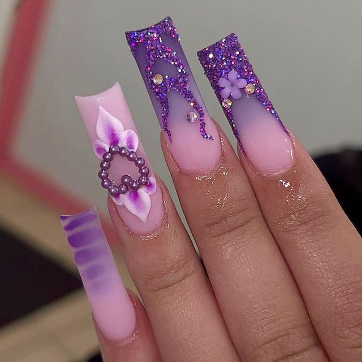 Elegant Ombre Nail Design with Glitter and Floral Accents in Pink and Purple.