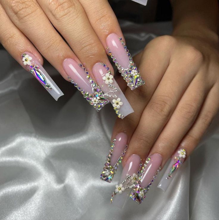 Elegant Glamorous Nail Design with Clear and Pink Acrylics, Rhinestones, and Floral Accents.