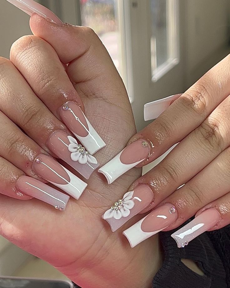 Chic Elegant Nail Design with Nude and White Floral Accents and Sparkling Gems