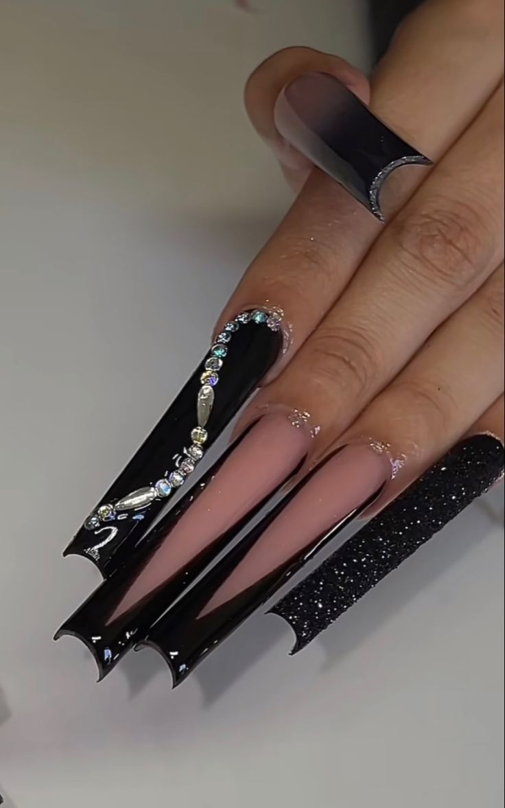 Elegant Nail Design with Glossy Black and Nude Shades, Rhinestones, and Bold Shapes for a Dramatic Statement.