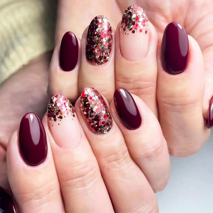 Chic Nail Design: Deep Burgundy with Glittering Gold and Red Accents for Festive Elegance.