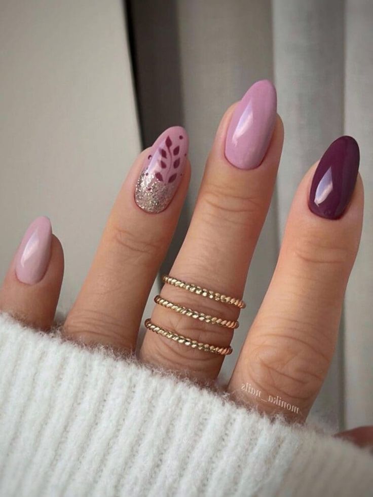 Chic Pastel Nail Design with Glitter and Artistic Leaf Patterns Enhanced by Stylish Stacked Rings.