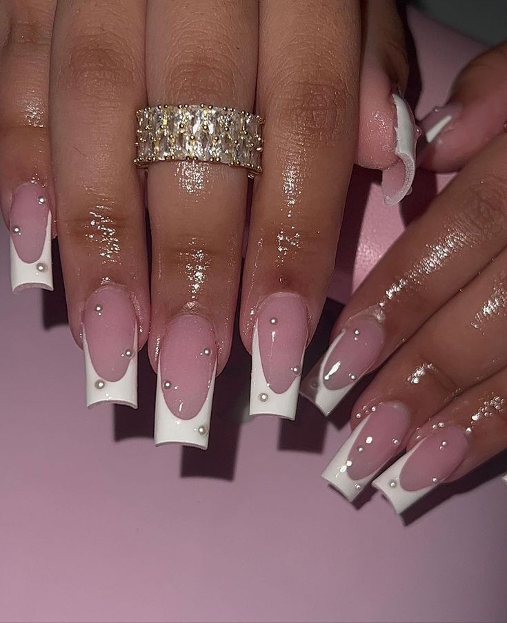 Sophisticated Soft Pink and Bold White Tips Nail Design with Pearl Accents and Glossy Finish.