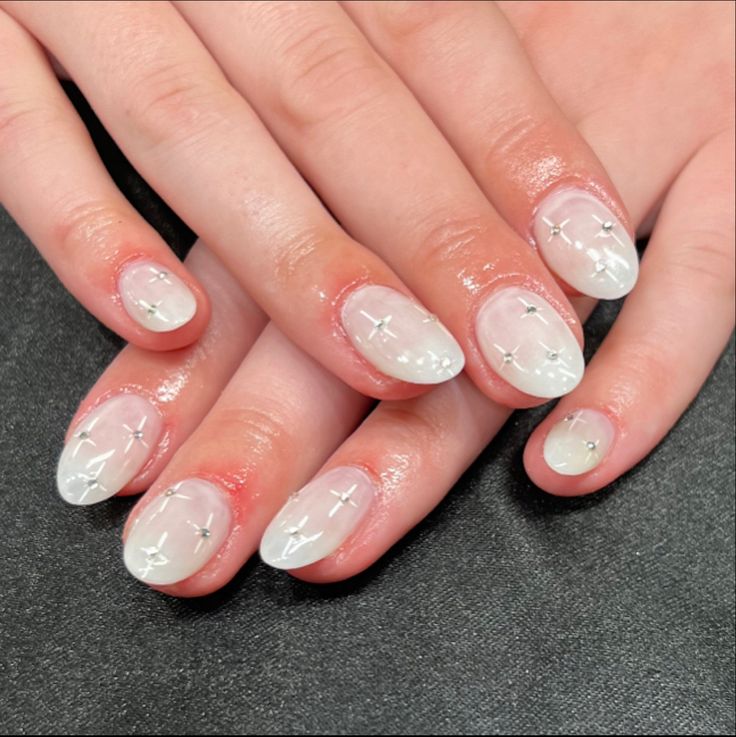 Chic White Glossy Nail Design with Delicate Silver Cross Accents.