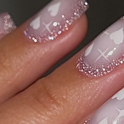 Romantic Gradient Nail Design with Shimmering Pink Tips and Heart Accents.