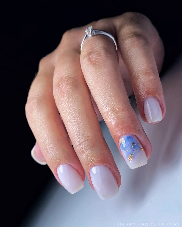 Chic Gradient Nail Design with Dreamy Blue Ombre and Sparkling Gold Flecks.