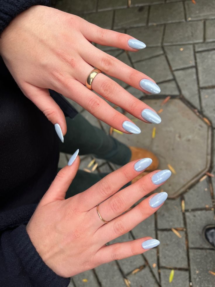 Chic Pastel Blue Almond-Shaped Nails Adorned with Minimalist Gold and Silver Rings