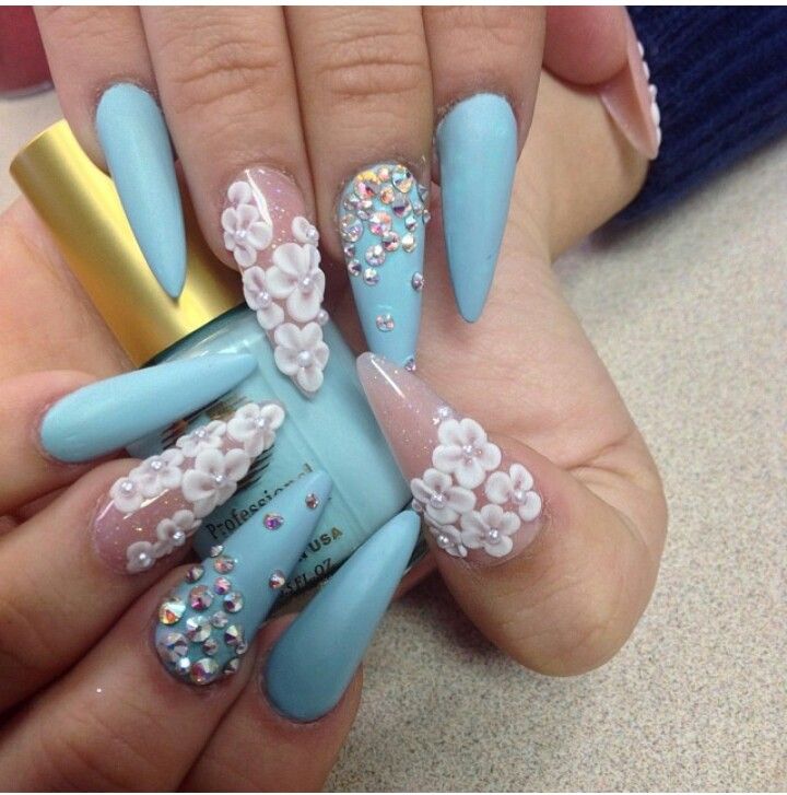 Chic Blue Nail Design with 3D Floral Embellishments and Glamorous Gemstones.