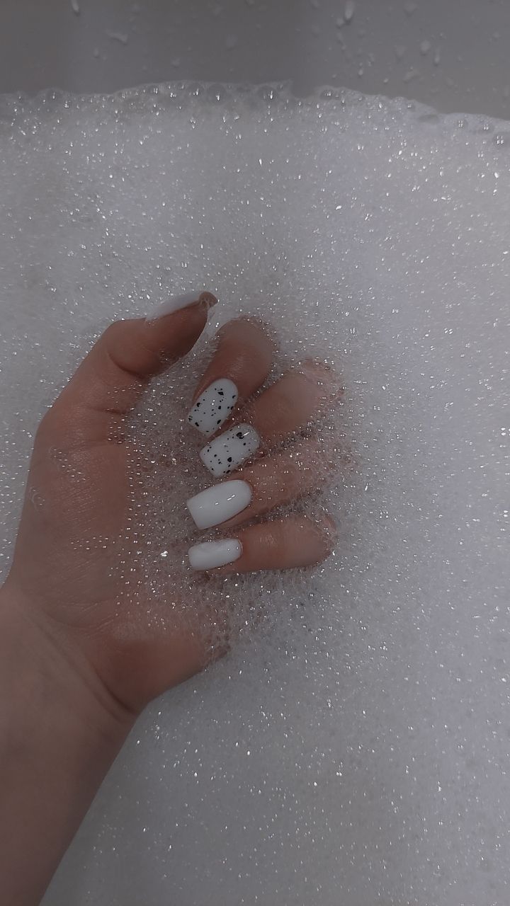 Chic Nail Design in Luxurious Bubbly Bath: Pristine White with Glitter Accents.