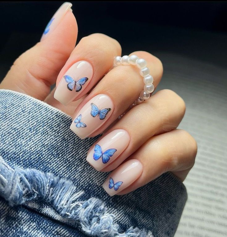 Whimsical Butterfly Nail Art: Elegant Blue Shades on a Clear Base