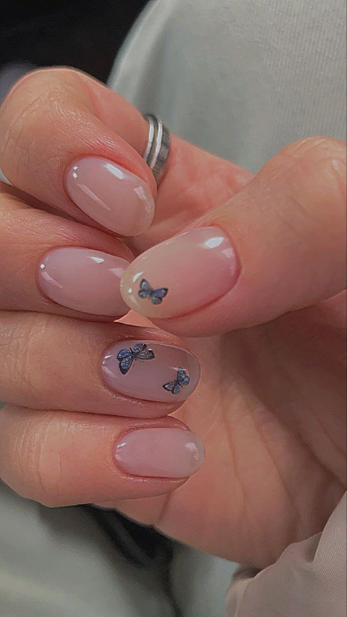 Charming Minimalistic Nail Design with Butterfly Accents in Soft Beige and Pink Tones.