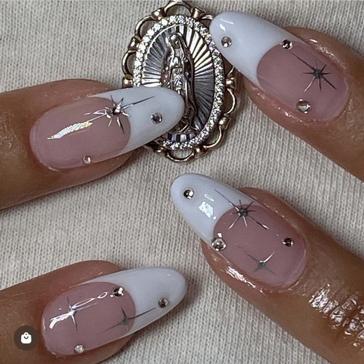 Elegant Nail Design with Soft Pink, Crisp White, Star Patterns, Gemstones, and Intricate Pendant Accents.