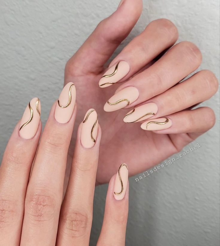 Chic Soft Nude Nails with Curvy Gold Accents for Any Occasion