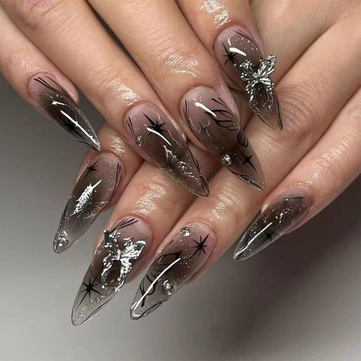 Sophisticated Stiletto Nails: Nude and Clear Polish with Intricate Silver and Black Designs.