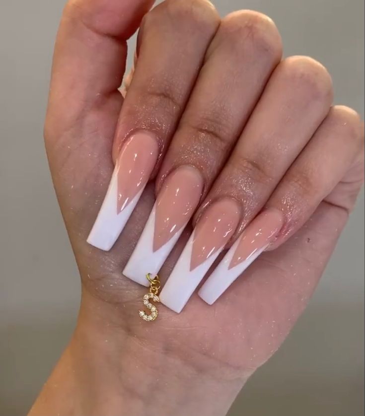 Elegant Stiletto Nail Design with Classic French Tips and Gold Charm Accent.