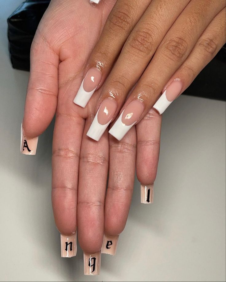 Elegant Nude and White Nail Design with French Tips and Decorative Lettering.