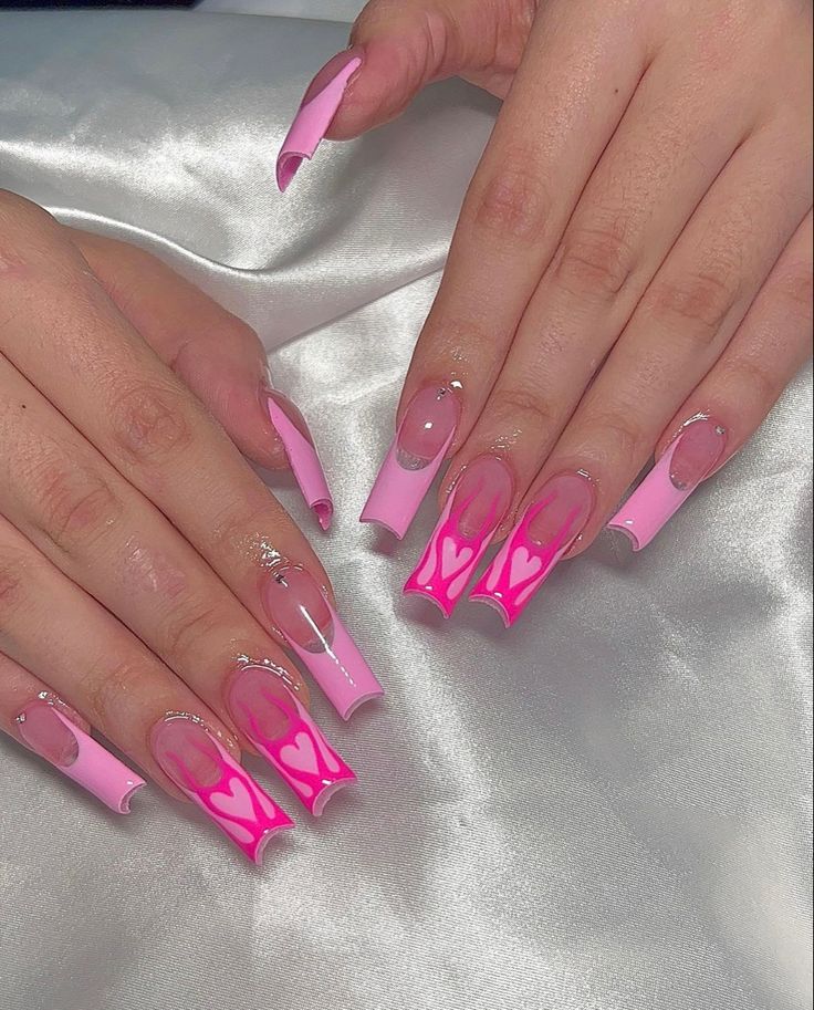 Chic Stiletto Nail Design in Vibrant Pink with Heart Patterns and Gemstone Accents.