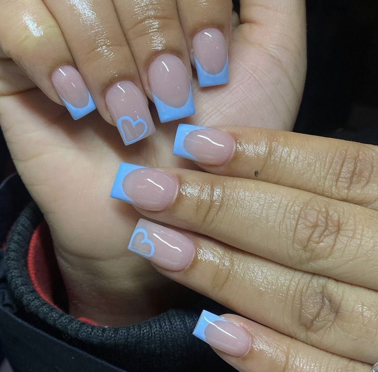 Chic Nail Design: Soft Nude and Pastel Blue with Heart Accents.