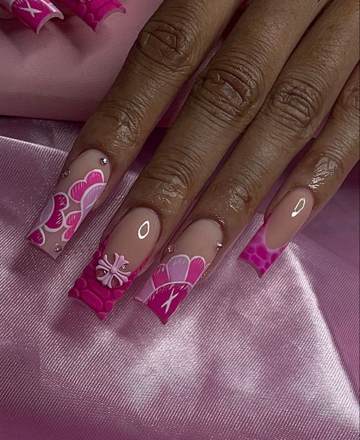 Playful Pink Nail Design with Bold Floral Patterns and Glossy Finishes.