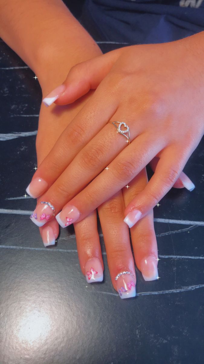 Sophisticated French Manicure with Floral Accents and Rhinestones