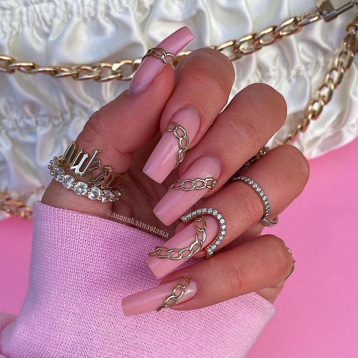 Chic Long Pink Acrylic Nails with Gold Chain Accents for a Glamorous Statement.