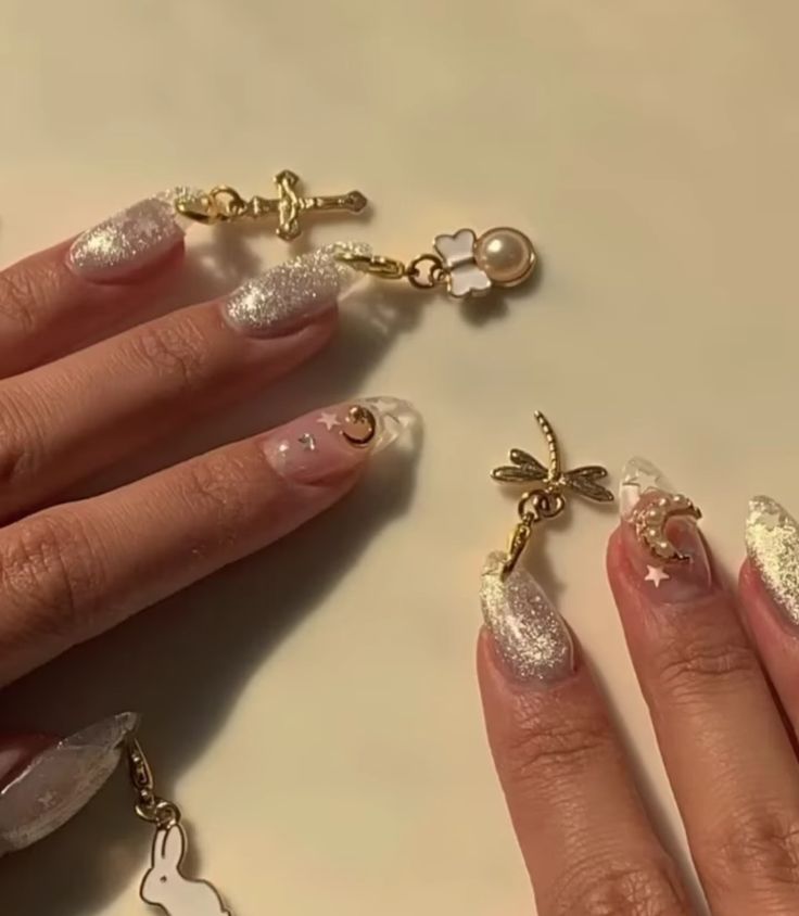 Whimsical Glittery Nail Design with Celestial Motifs and Playful Charms.